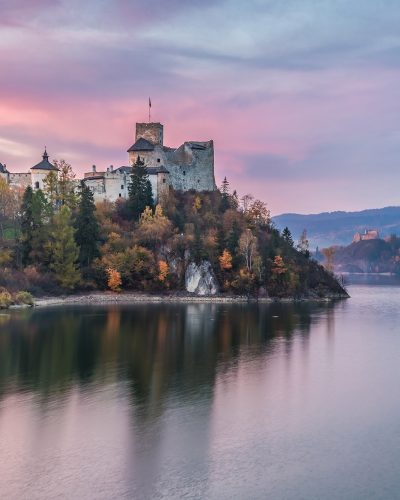 Wonderful castle by the lake at dusk in autumn