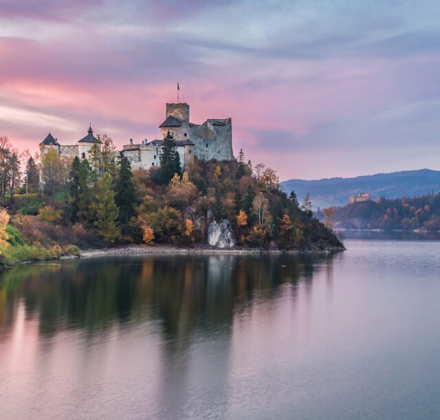 Wonderful castle by the lake at dusk in autumn